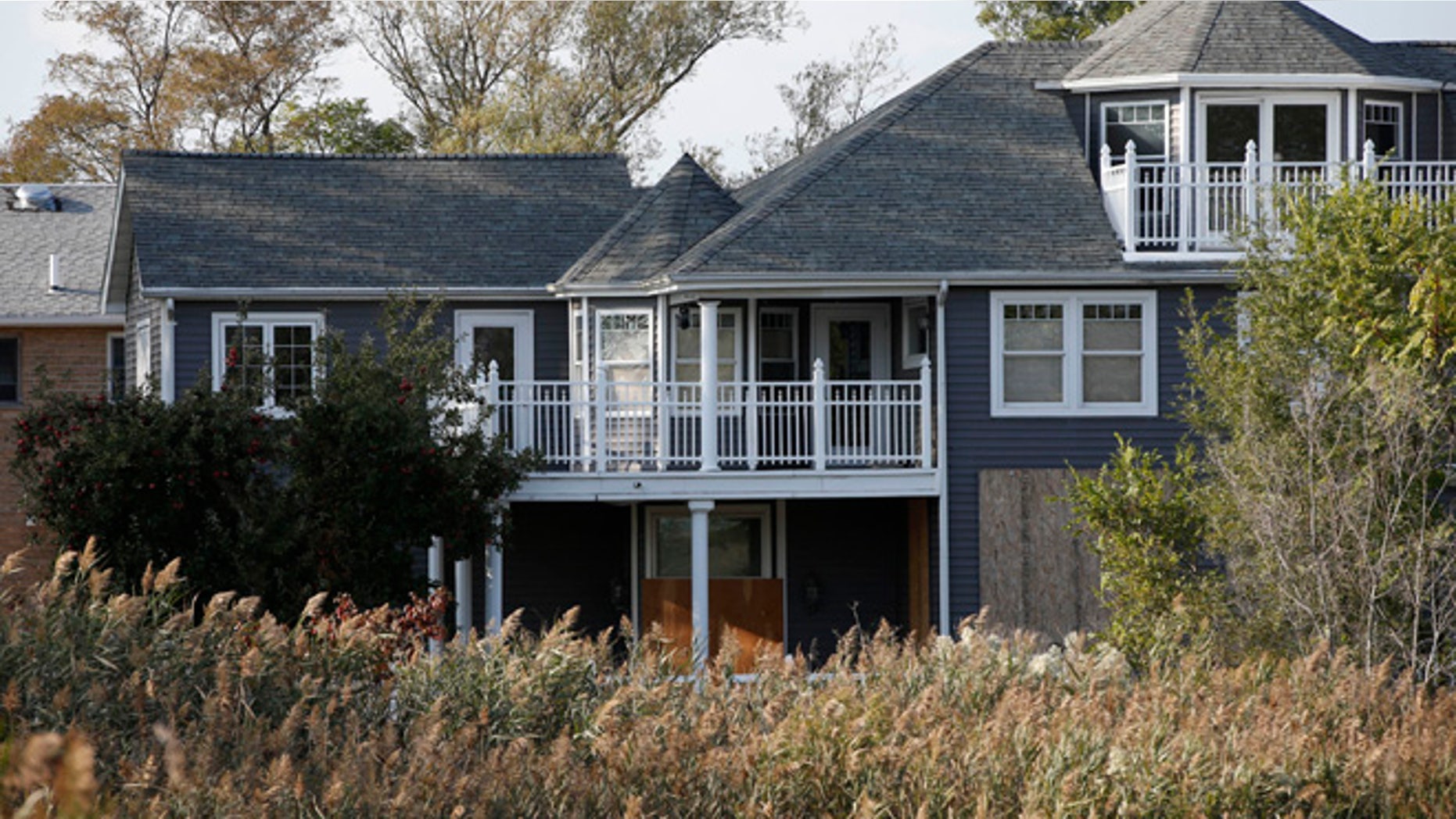 Oct. 2, 2013: This photo shows Joe Monte's abandoned Oakwood Beach dream house, boarded-up behind overgrown invasive phragmite plants, in the Staten Island borough of New York. Monte has hardly set foot in the house he spent 20 years building since Superstorm Sandy breached nearby sand dunes, flooding the area and severely damaging the property. Monte is among over 400 homeowners that will receive buyouts from the state so they can relocate and rebuild in less vulnerable vulnerable areas.