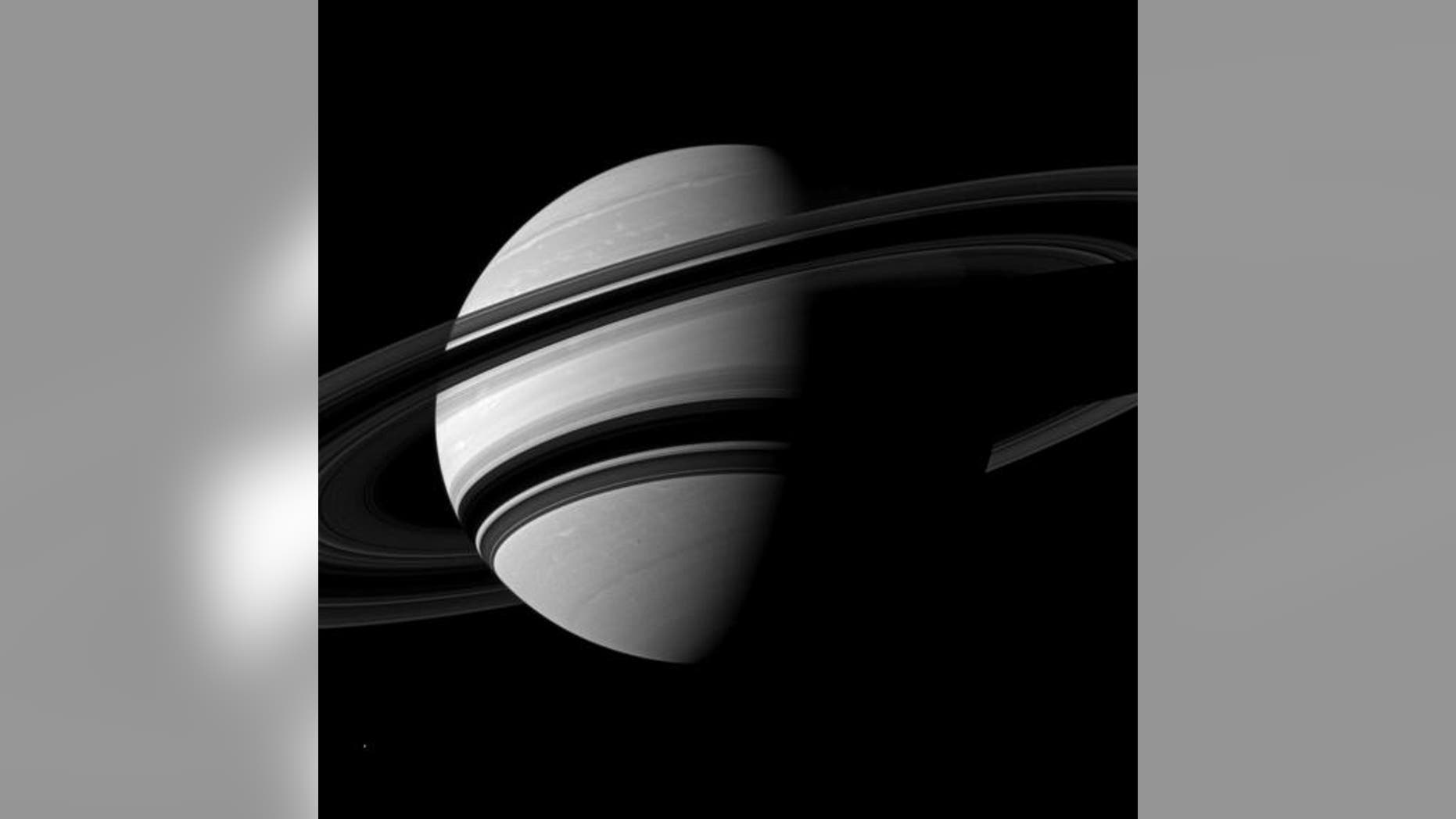 NASA's Cassini spacecraft snapped this angled shot of Saturn, showing the southern reaches of the planet with the rings on a dramatic diagonal. Saturn's icy moon Enceladus is visible as a tiny white speck in the lower lefthand corner. The pictu