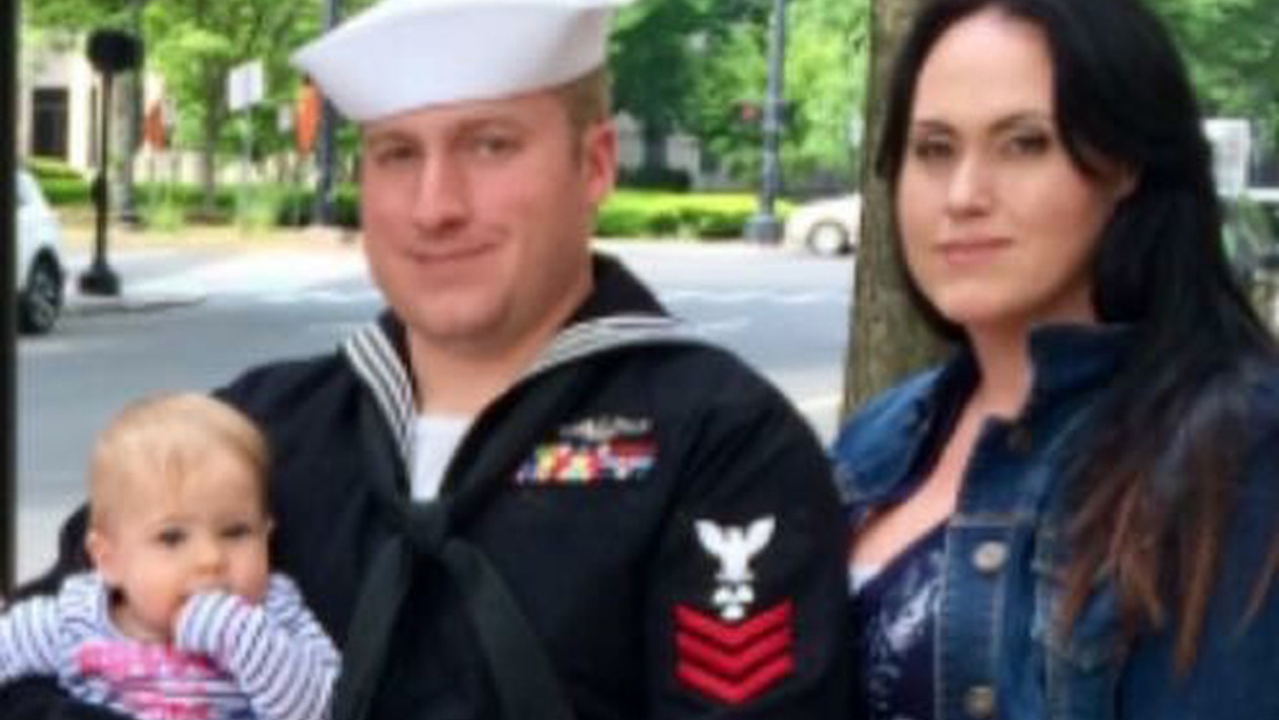 Former Navy sailor Kristian Saucier with his child, Kassy, and wife, Sadie