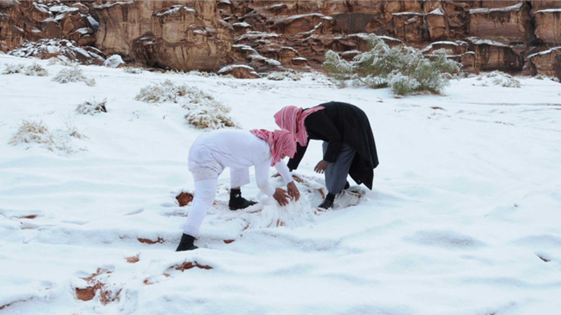 Dec. 13, 2013: Saudi men make a snowman after a snowstorm in Alkan village, west of Saudi Arabia.