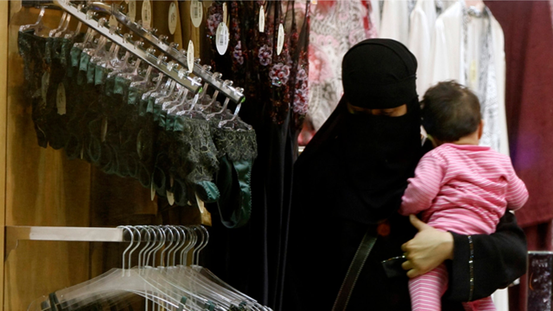 March 25, 2009: FILE -- In this file photo, a Saudi woman holding a child checks out lingerie at a store in Riyadh, Saudi Arabia.