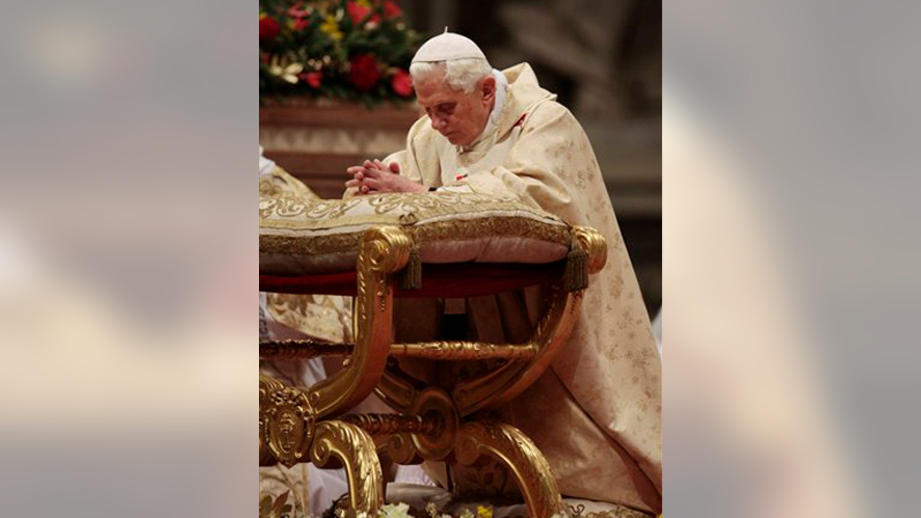 Pope Benedict XVI kneels in prayer during Christmas Mass in St. Peter's Basilica at the Vatican, Thursday, Dec. 24, 2009. A woman jumped the barriers in St. Peter's Basilica and knocked down the pontiff as he walked down the main aisle to begin Christmas Eve Mass on Thursday, a Vatican spokesman said. The Rev. Ciro Benedettini said the 82-year-old pope quickly got up and was unhurt. (AP Photo/Gregorio Borgia)
