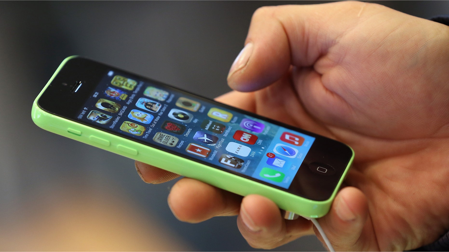 BERLIN, GERMANY - SEPTEMBER 20: A customer tries out the new Apple iPhone 5C smartphone at the Berlin Apple Store on the first day of sales on September 20, 2013 in Berlin, Germany. The new iPhone 5S and 5C phones went on sale all over the world today and hundreds of customers waited outside the Berlin store in the rain to be among the first to buy the new phones starting at 8am. (Photo by Sean Gallup/Getty Images)