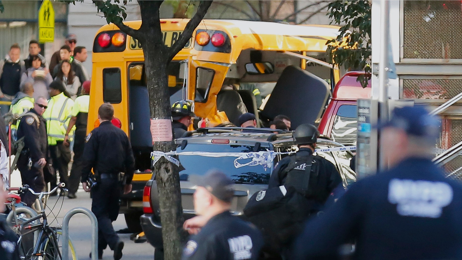 Authorities respond near a damaged school bus Tuesday, Oct. 31, 2017, in New York. A motorist drove onto a busy bicycle path near the World Trade Center memorial and struck several people on Tuesday police and witnesses said. (AP Photo/Bebeto Matthews)