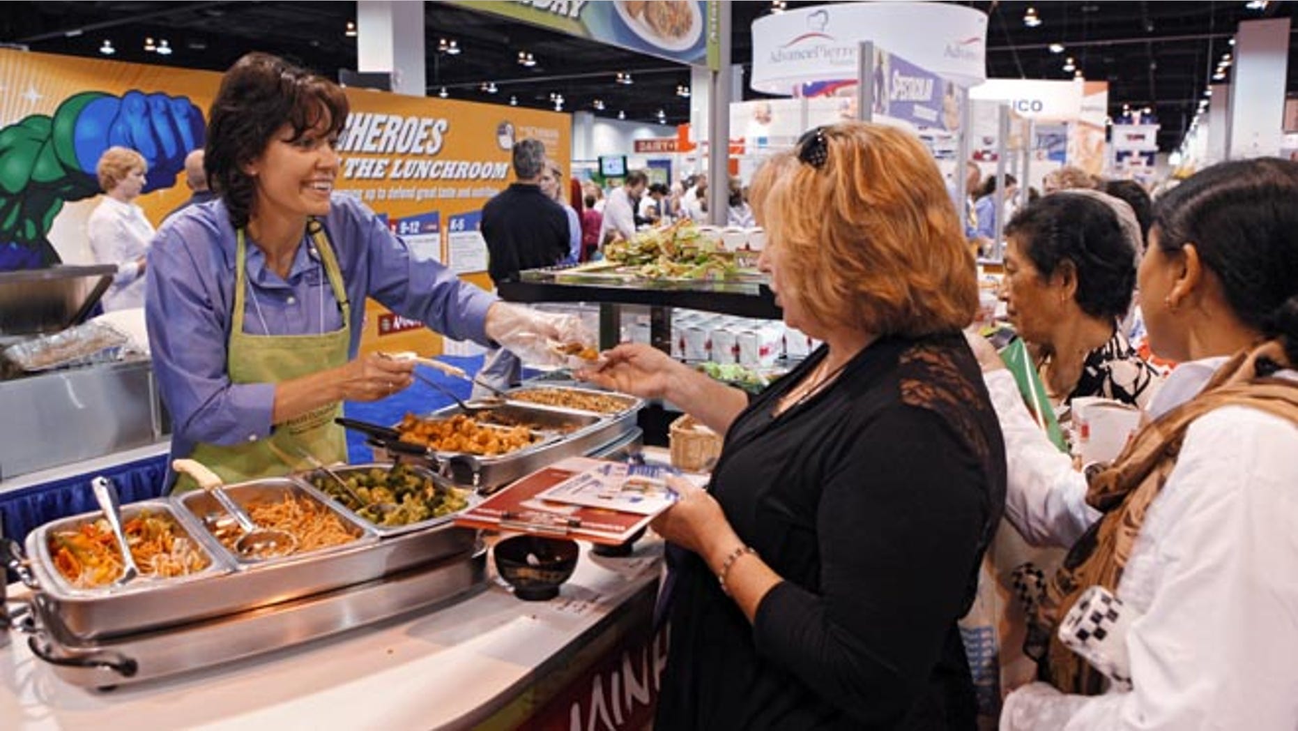 July 17, 2012: Diane Wagner, with Schwan Food Co., hands out samples at a booth during the School Nutrition Association conference in Denver.
