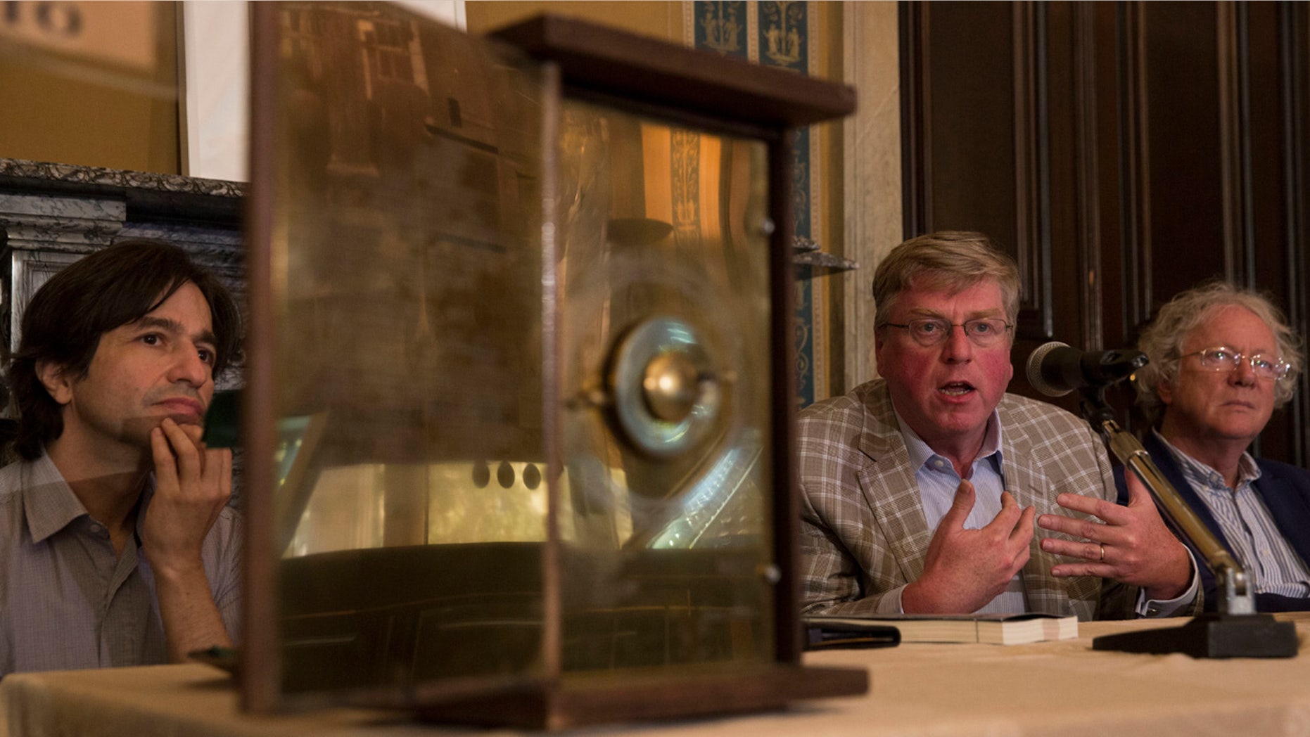 June 9, 2016: Alexander Jones, center, Mike Edmunds, right, and Yanis Bitsakis sit behind a possible reconstruction of the more than 2,000-year-old Antikythera Mechanism during a press conference in Athens