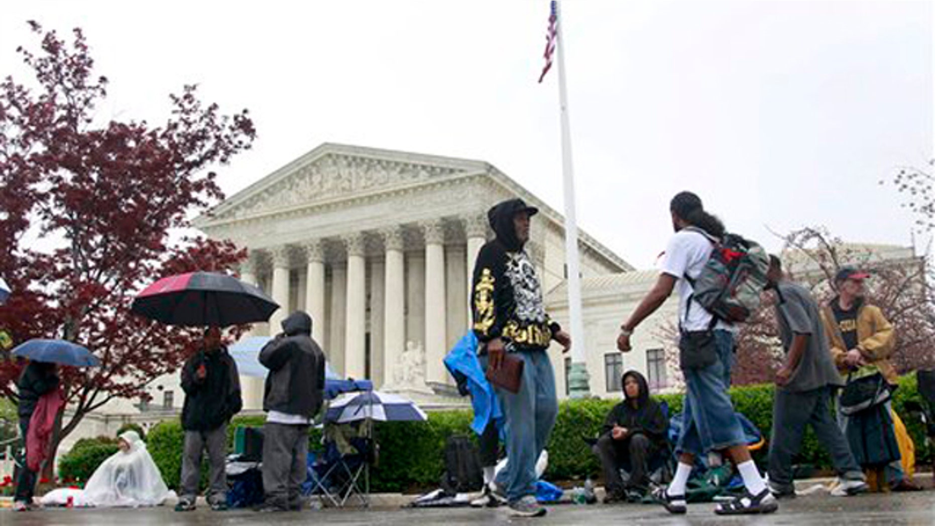 March 24, 2012: People walk in front of the Supreme Court as others form a line, in advance of arguments regarding the federal health care overhaul challenge.