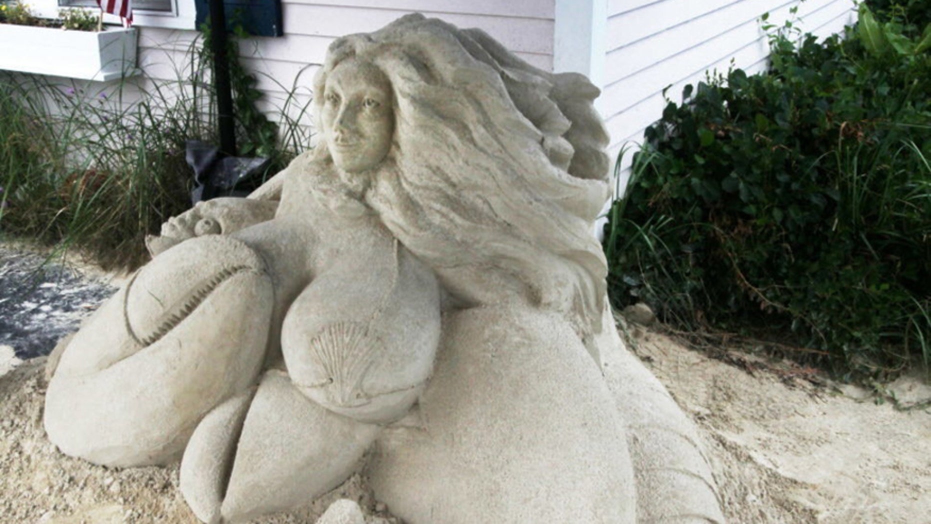 This July 7, 2016 photo shows the mermaid sand sculpture in front of Salty's Seafood Restaurant in West Yarmouth, Mass. Here, the sand sculpture is under a small tent enclosure outside the restaurant and is part of a larger collection of sculptures throughout Yarmouth.