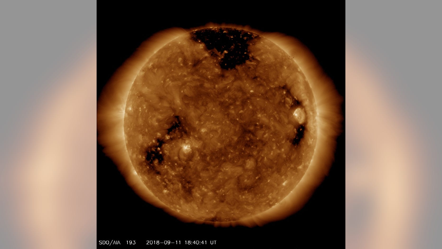 NASA's Solar Dynamics Observatory spacecraft captured this image of a giant hole (dark patch at top) in the sun's outer atmosphere, or corona, on Sept. 11, 2018.