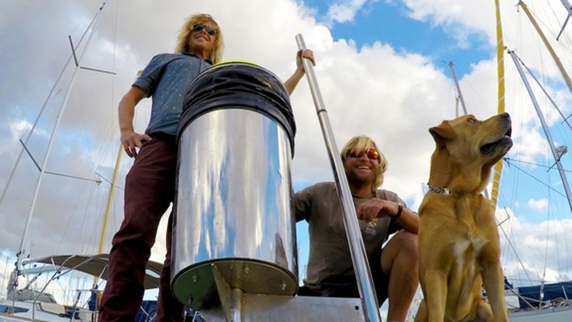 A photograph of the inventors with a prototype of their Seabin device.
