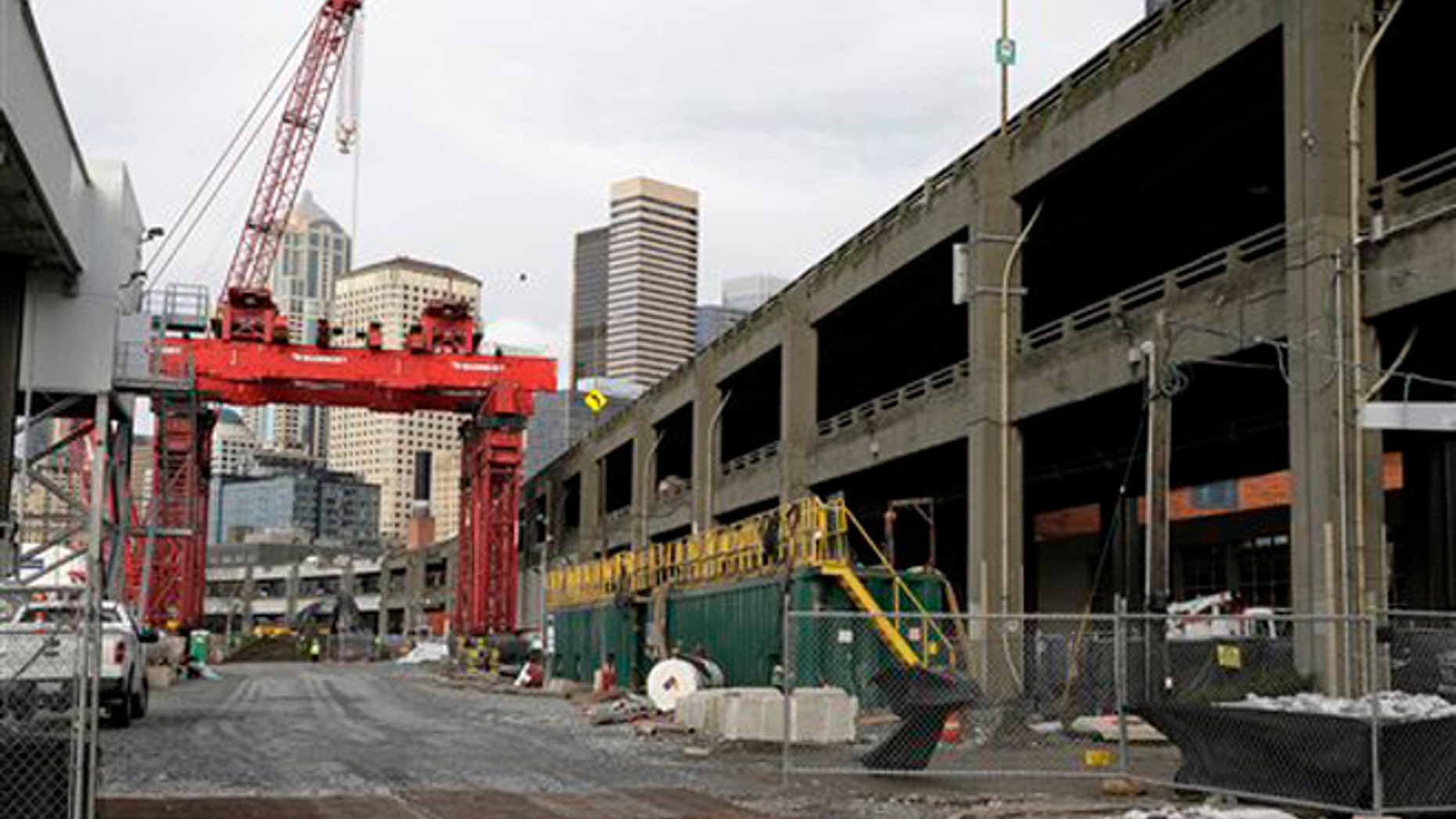 A crane is shown Friday, Dec. 18, 2015, at the site in Seattle, where an access pit had been dug to repair "Bertha," the massive tunnel boring machine digging a replacement for the Alaskan Way Viaduct elevated roadway, after it hit an underground pipe more than two years ago. Officials have said that the machine could resume tunneling as early as next week. (AP Photo/Ted S. Warren)