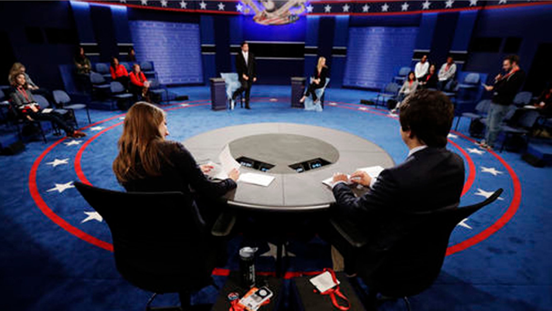 Students stand in on the stage as preparations are made for the second presidential debate between Republican presidential nominee Donald Trump Democratic presidential nominee Hillary Clinton at Washington University in St. Louis, Saturday, Oct. 8, 2016. (AP Photo/Julio Cortez)