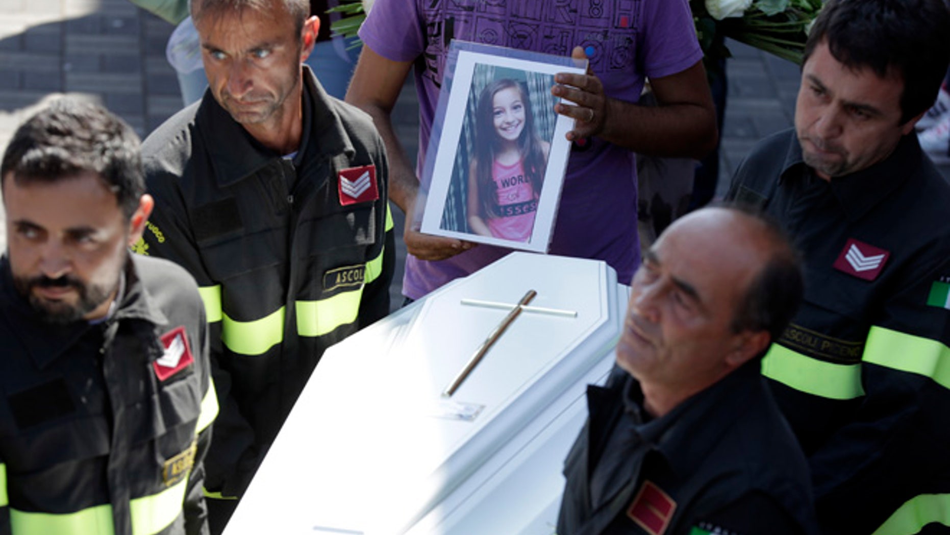 The coffin of Giulia, 9 years old, is carried outside the gymnasium at the end of the state funeral service in Ascoli Piceno, Italy,.