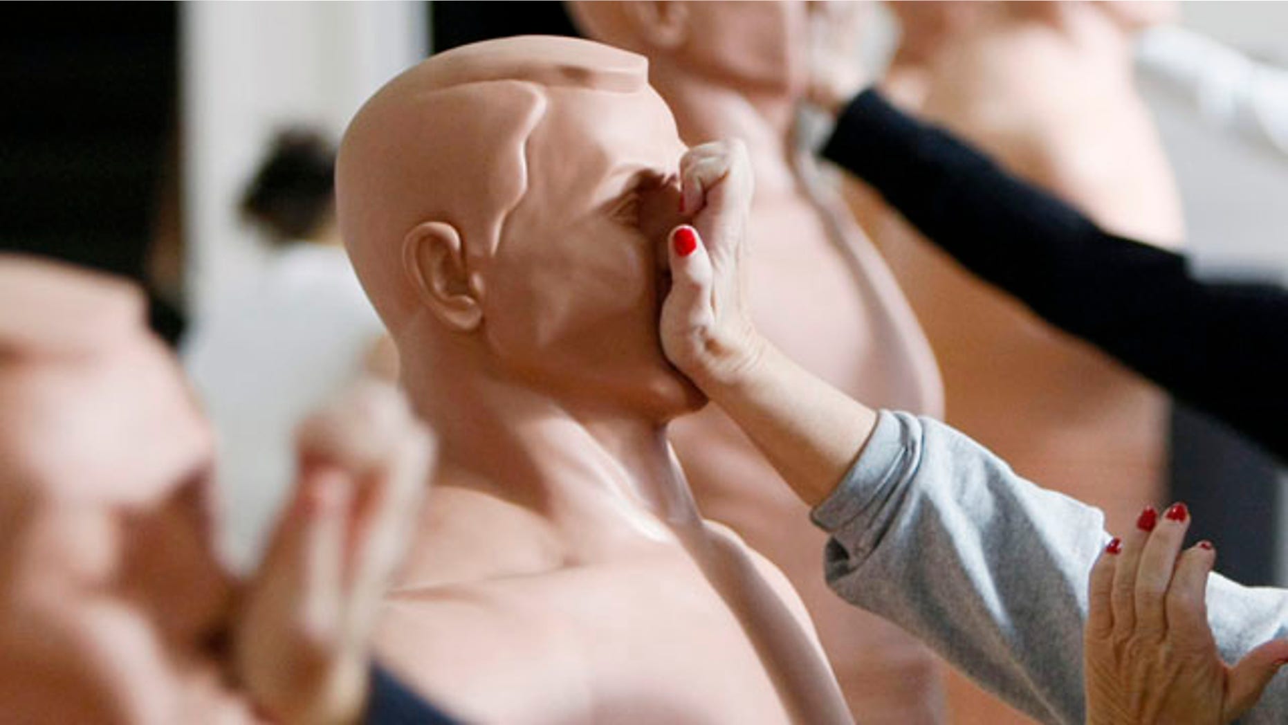 Women practice strikes against rubber mannequins during a self-defense course in Denver.