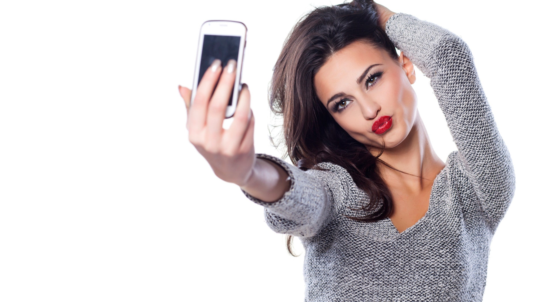 pretty girl make a duck face, and take a self portrait with her smart phone