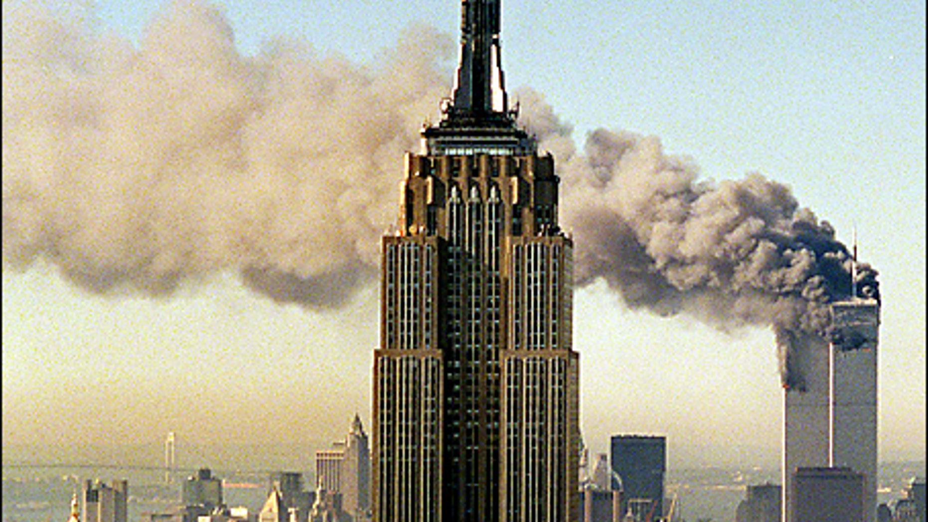FILE: The twin towers of the World Trade Center burn behind New York's Empire State Building in this Sept. 11, 2001 file photo. (AP Photo/Marty Lederhandler, File)