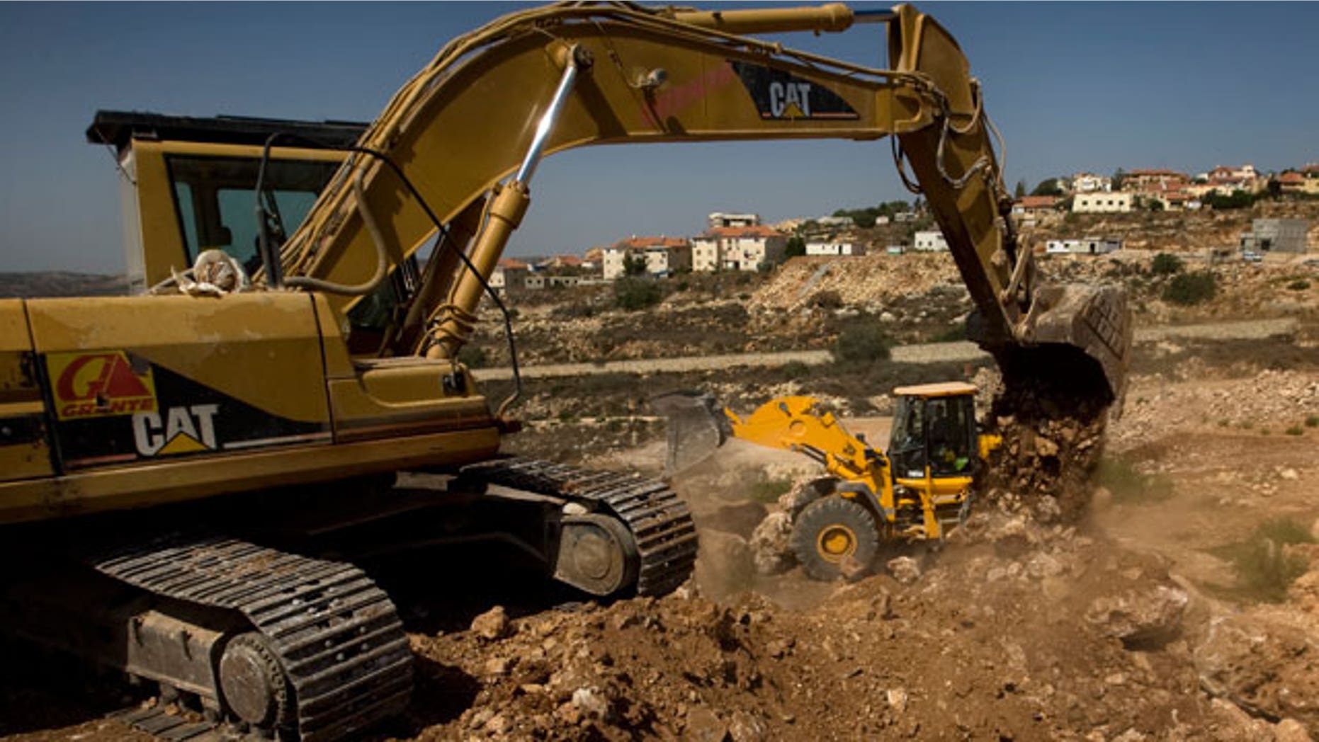 FILE: This Sept. 28, 2010, photo shows workers using ground moving equipment at a construction site in the Jewish settlement of Revava, near the West Bank city of Nablus.