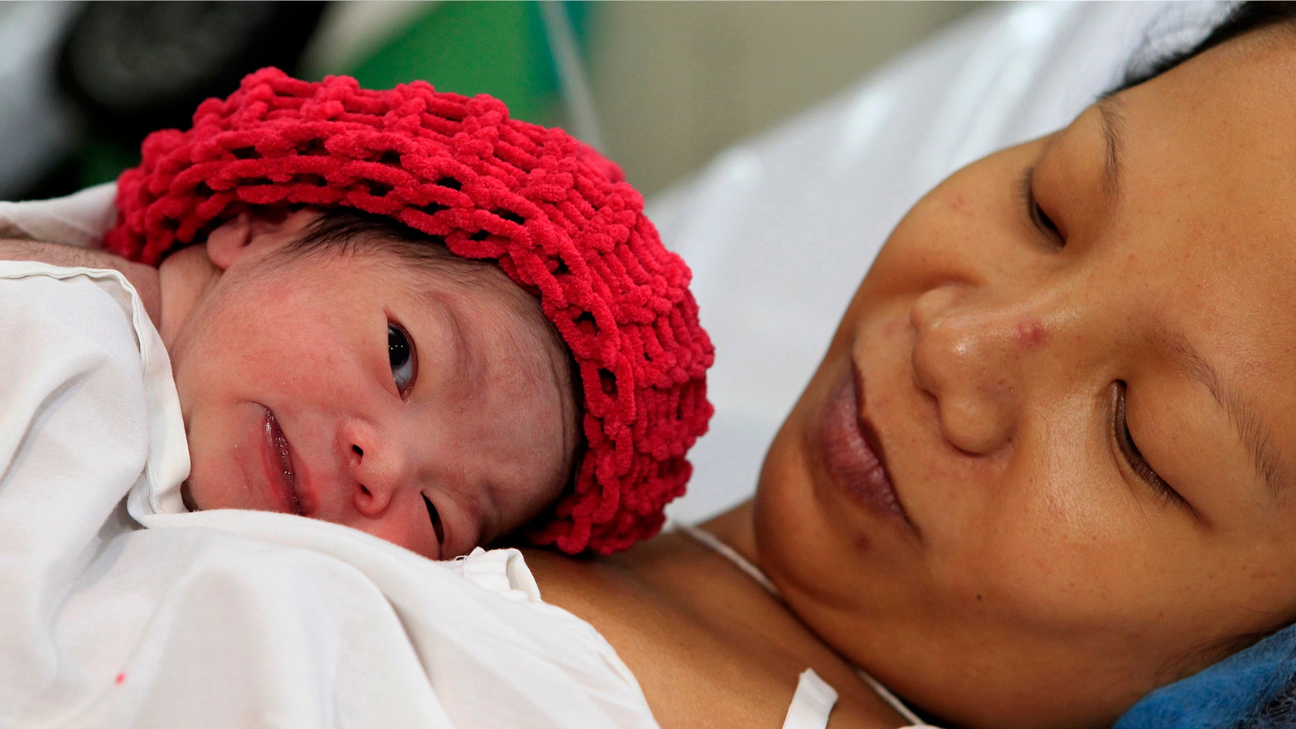 Oct. 31, 2011: A newly born baby girl named Danica Camacho, the Philippines' symbolic seven billionth baby, as part of the United Nations' seven billion global population projection, lies on the chest of her mother Camille in government's Fabella Maternity hospital in Manila.