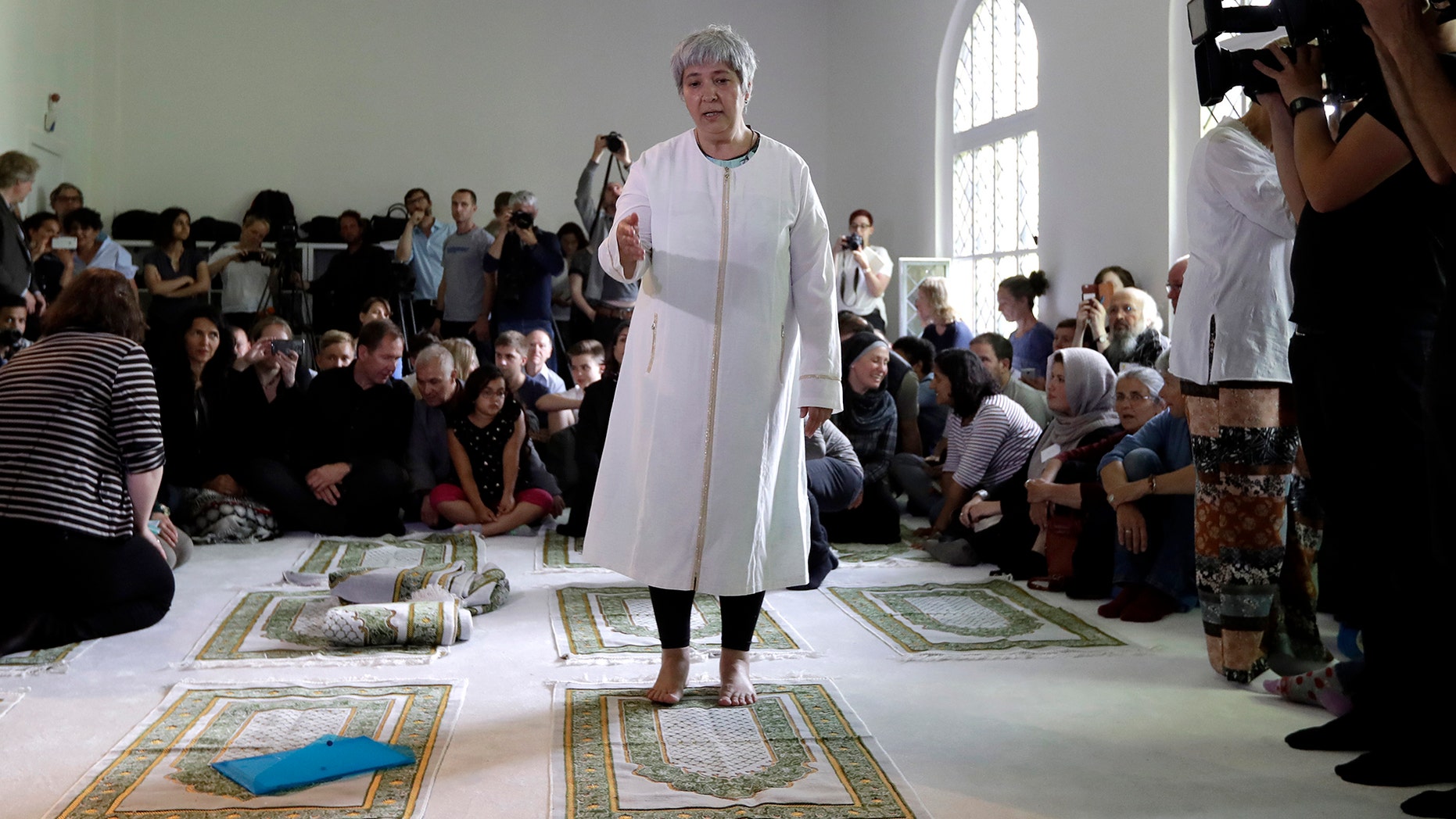 Seyran Ates, standing at center, founder of the Ibn-Rushd-Goethe-Mosque gestures during the opening of the mosque in Berlin, Germany, Friday, June 16, 2017.