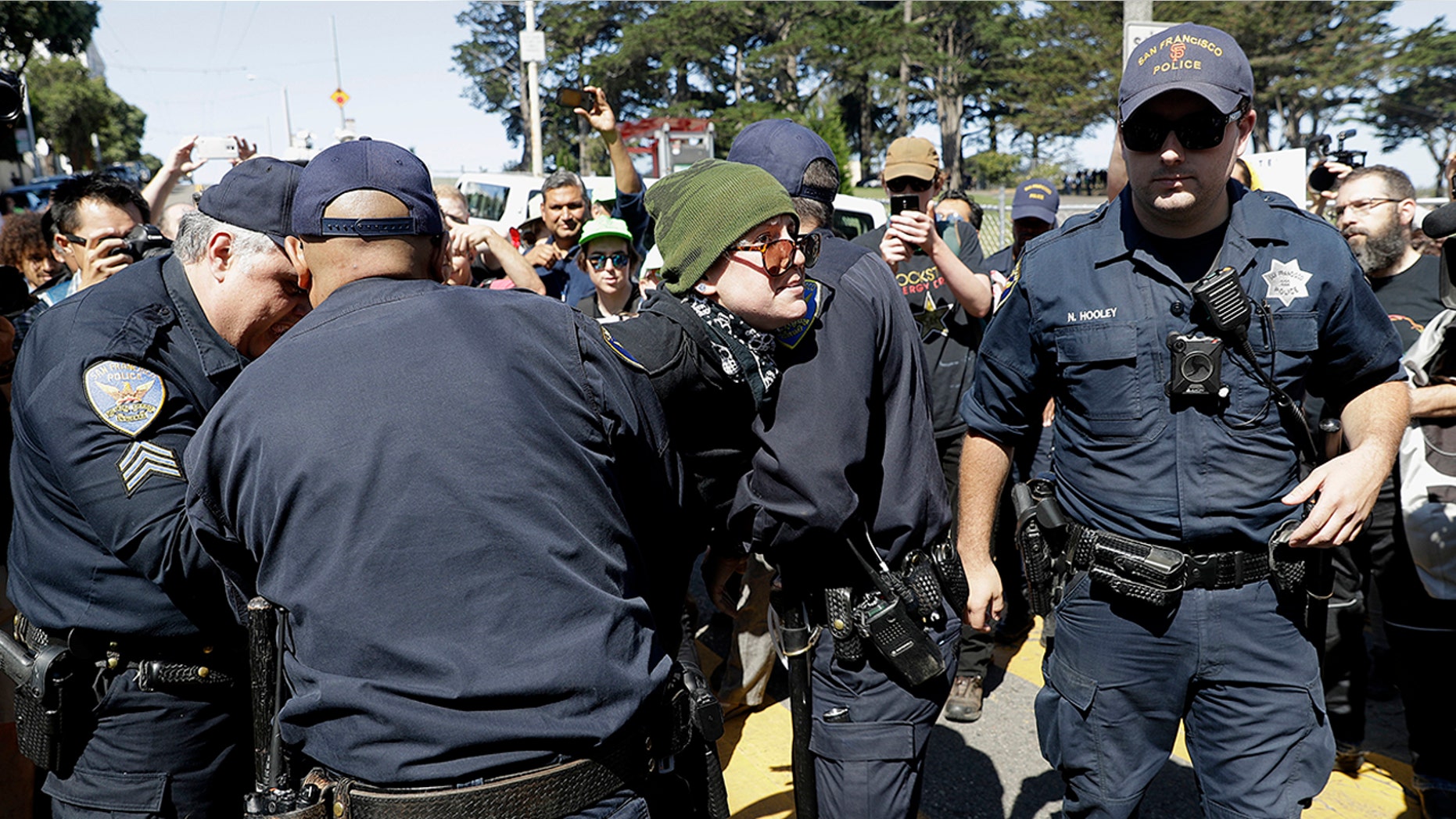 San Francisco Police officers arrest a protester outside of Alamo Square Park Saturday.