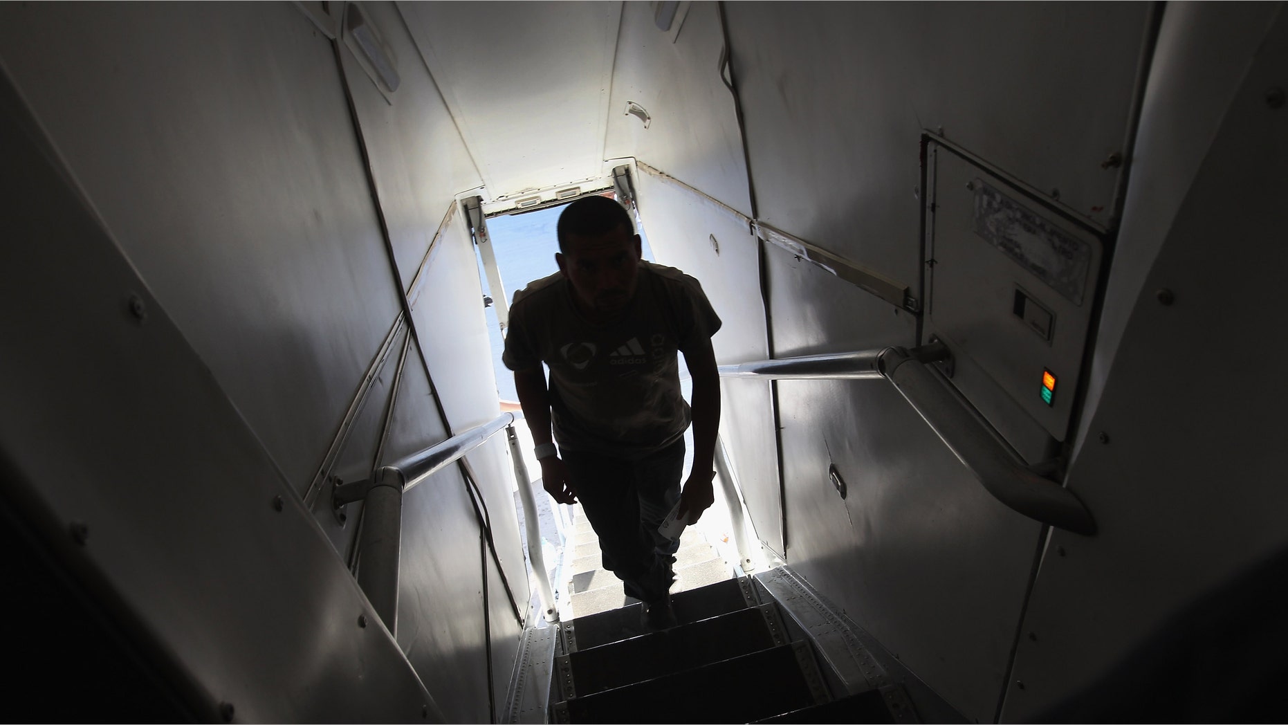 MESA, AZ - JUNE 24: An undocumented Guatemalan immigrant boards a deportation flight to Guatemala City, Guatemala at Phoenix-Mesa Gateway Airport on June 24, 2011 in Mesa, Arizona. The U.S. Immigration and Customs Enforcement agency, ICE, repatriates thousands of undocumented Guatemalans monthly, many of whom are caught in the controversial "Secure Communities" data-sharing program which puts local police on the frontlines of national immigration enforcement. ICE recently announced a set of adjustments to the federal program after many local communities and some states, including New York, insisted on opting out, saying immigrants were being deported for minor offenses such as traffic violations. Guatemala ranks only second to Mexico in the number of illegal immigrants deported from the United States. (Photo by John Moore/Getty Images)
