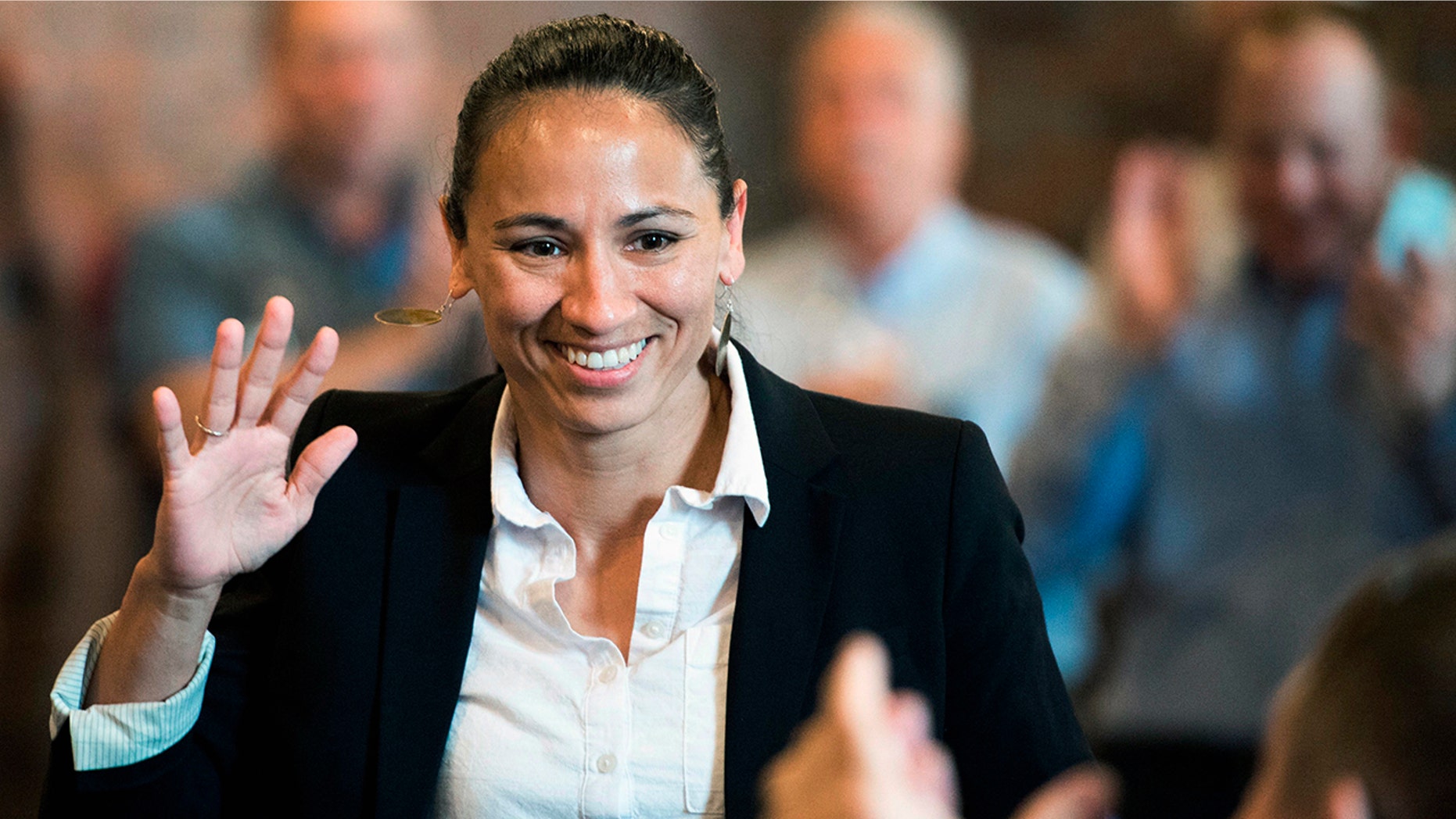 Democrat Sharice Davids waves at her supporters at a Democratic event in Kansas City, Kan., Aug. 8, 2018.