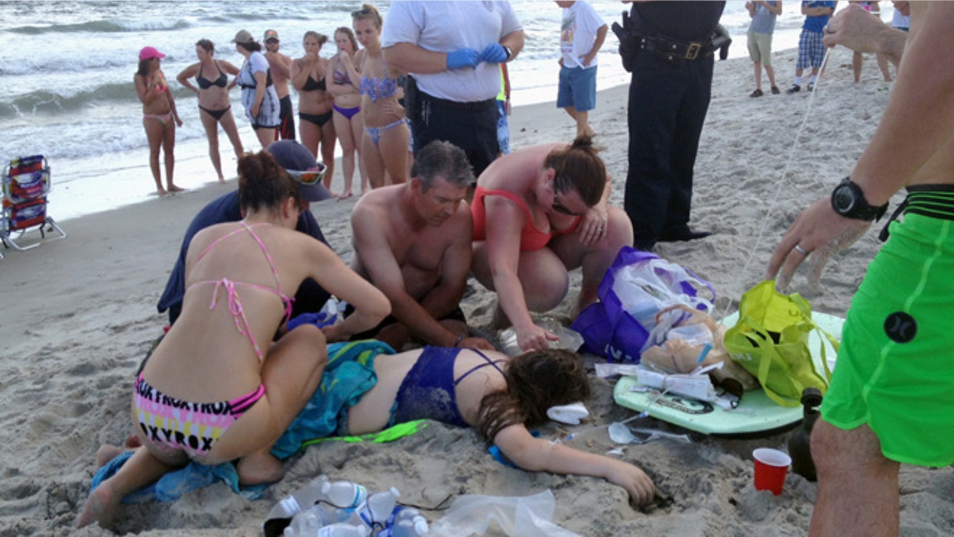 June 14, 2015: Emergency responders assist a teenage girl at the scene of a shark attack in Oak Island, N.C..