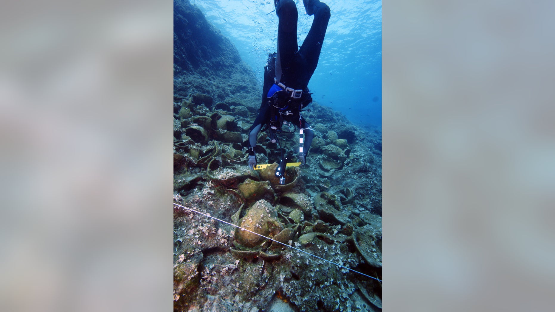 An archaeologist prepares a level on one of the wrecks.