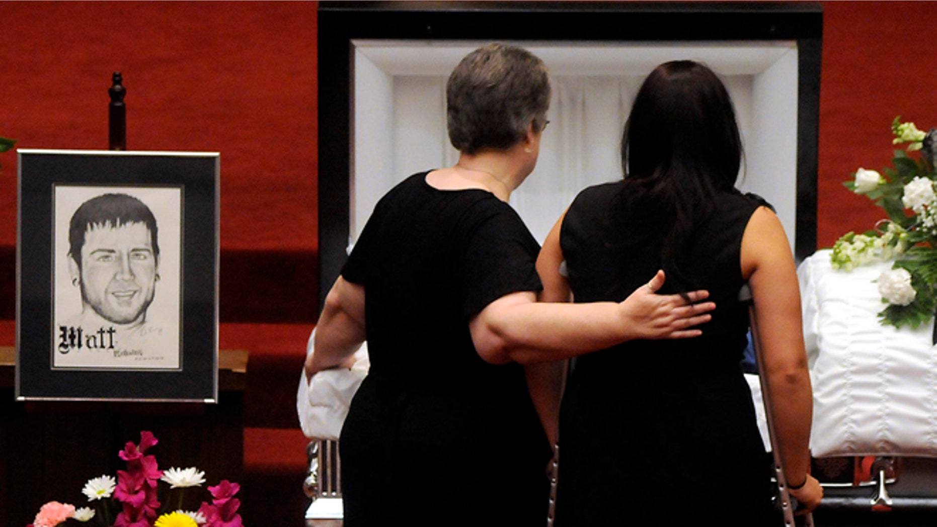 July 28, 2012: Samantha Yowler, right, pays her final respects to boyfriend Matt McQuinn, at the Maiden Lane Church of God, in Springfield, Ohio. McQuinn shielded his girlfriend, Yowler, from gunfire during the shooting at the Aurora, Colo., movie theater on July 20.