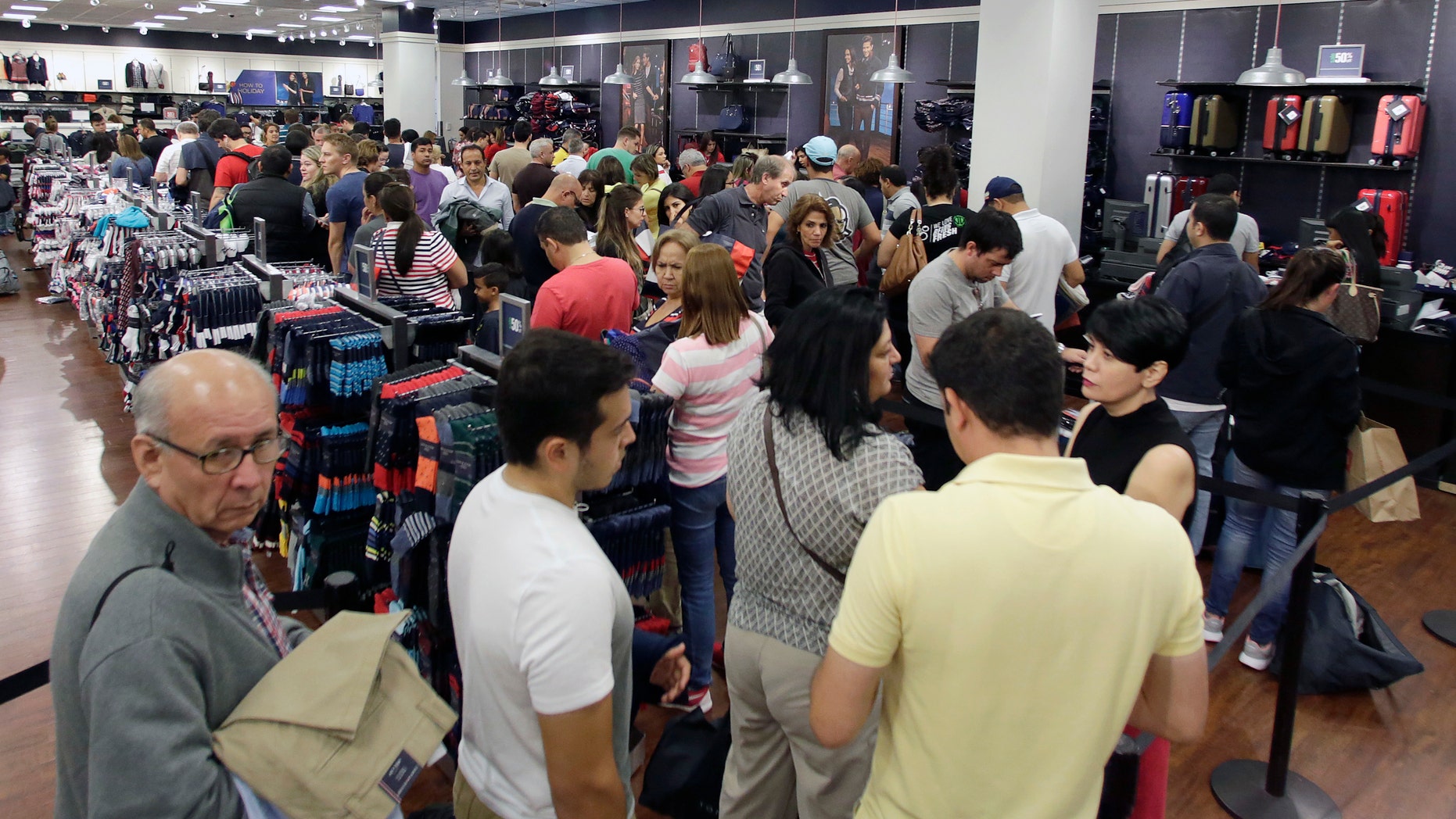 Shoppers stand in line to pay for their purchased merchandise at a Tommy Hilfiger store on Black Friday, Nov. 25, 2016, in Miami. Stores opened their doors Friday for what is still one of the busiest days of the year, even as the start of the holiday season edges ever earlier. (AP Photo/Alan Diaz)