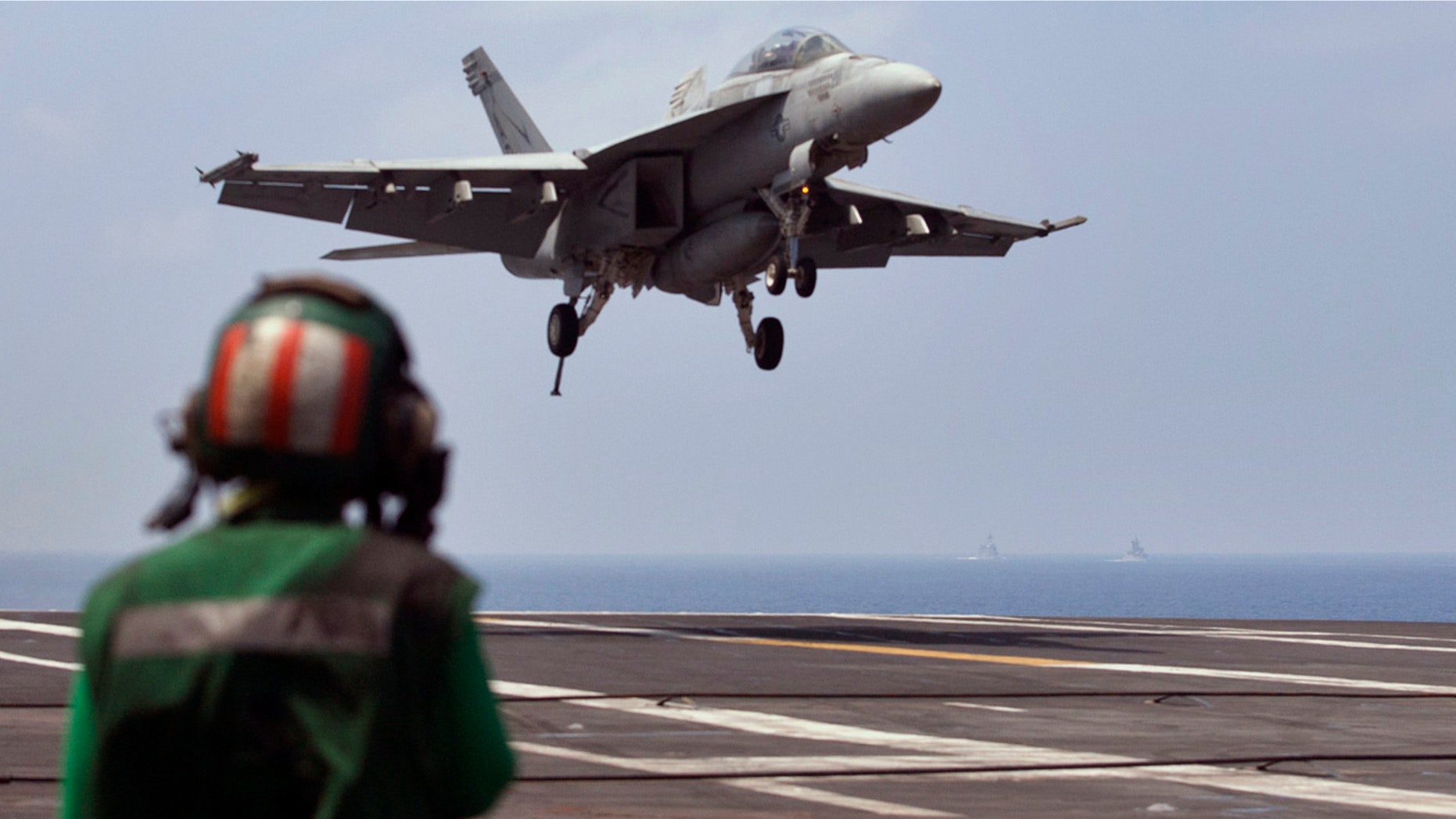 FILE - This Oct. 17, 2015 file photo shows a U.S. Navy fighter jet approaching to land on the U.S. Navy aircraft carrier USS Theodore Roosevelt during Exercise Malabar 2015 about 150 miles off Chennai, India. (AP Photo/Arun Sankar K., File)