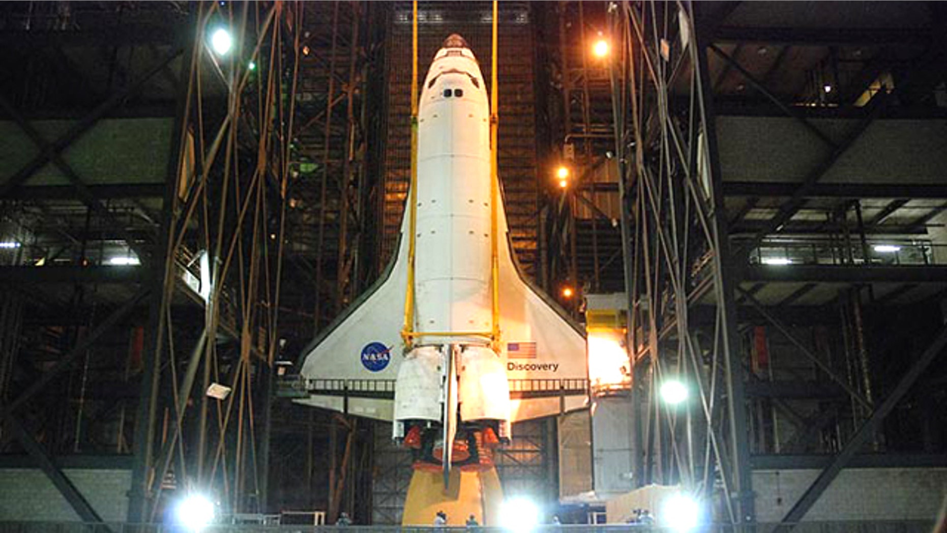 Space shuttle Discovery is hoisted into position to be attached to its external tank and solid rocket boosters for its final launch into space on the STS-133 mission to the International Space Station.