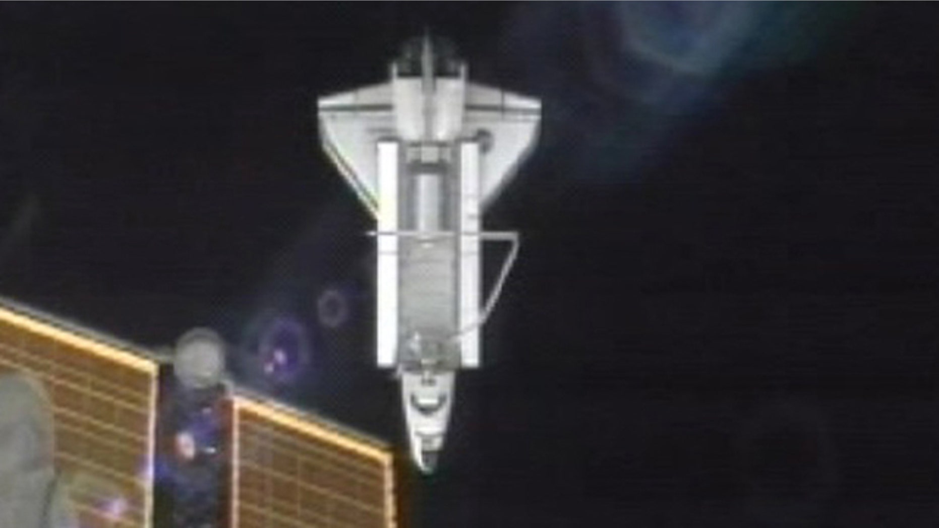 July 19: A photo made from NASA television shows the Atlantis as it passes under a solar panel on the Internatoinal Space Station after undocking.