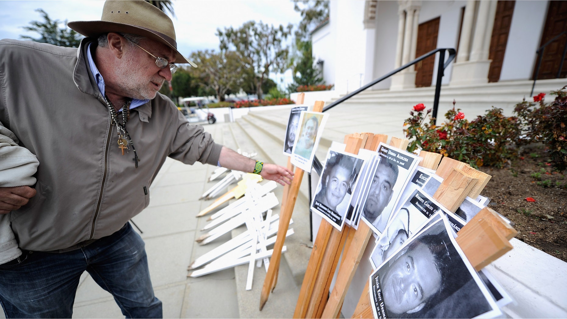 LOS ANGELES, CA - APRIL 25: Javier Sicilia, poet and leader of the Mexican anti-drug group Movement for Peace with Justice and Dignity, picks up a poster to lead a 50-cross procession at Loyola Marymount University on April 25, 2012 in Los Angeles, California. The procession led by Sicilia was to raise awareness on the drug wars in Mexico and the United States and to protest drug-related killings, with each cross representing 1,000 victims. (Photo by Kevork Djansezian/Getty Images)