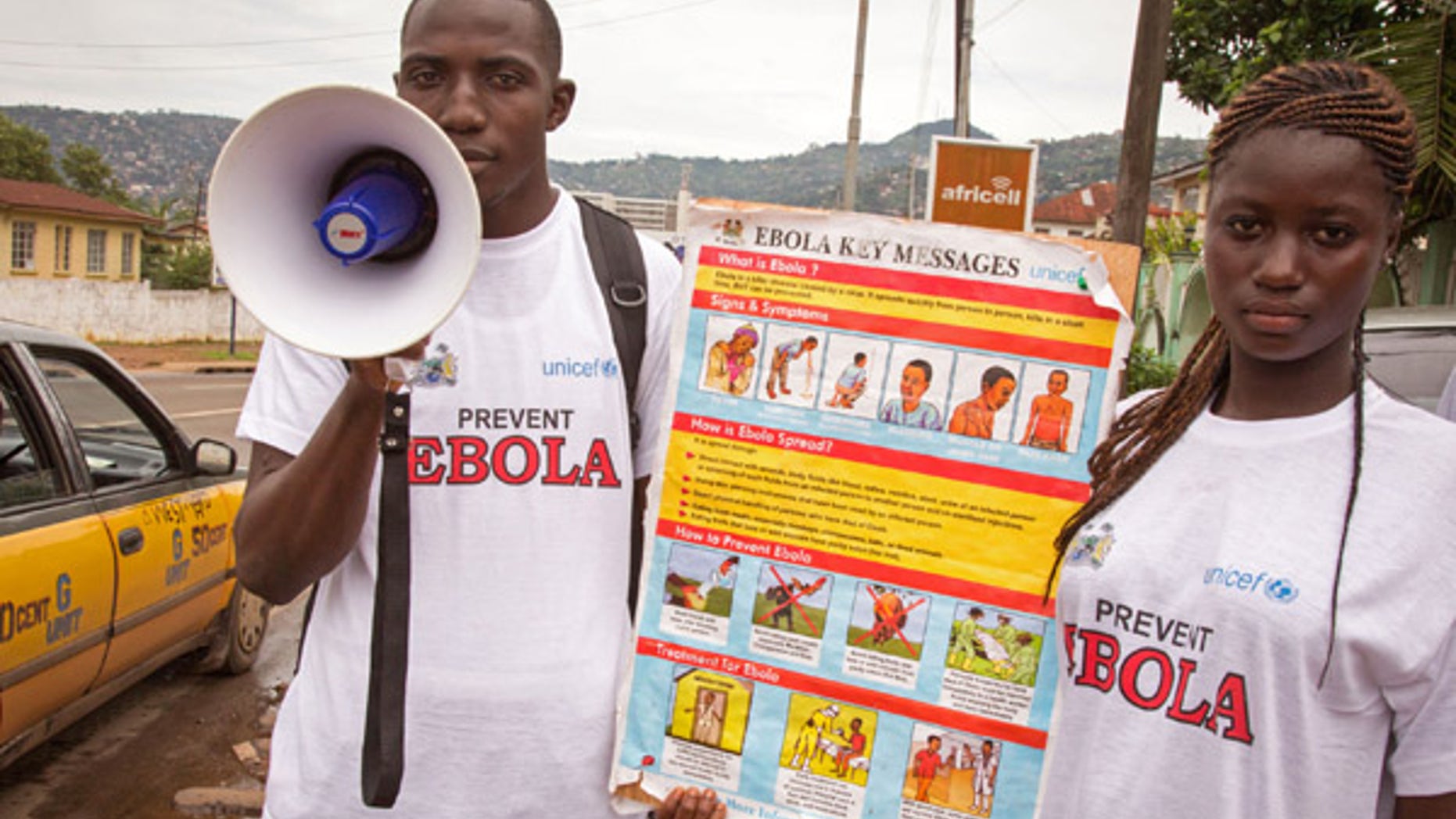 Aug. 6, 2014: A man and woman taking part in a Ebola prevention campaign holds a placard with an Ebola prevention information message in the city of Freetown, Sierra Leone.
