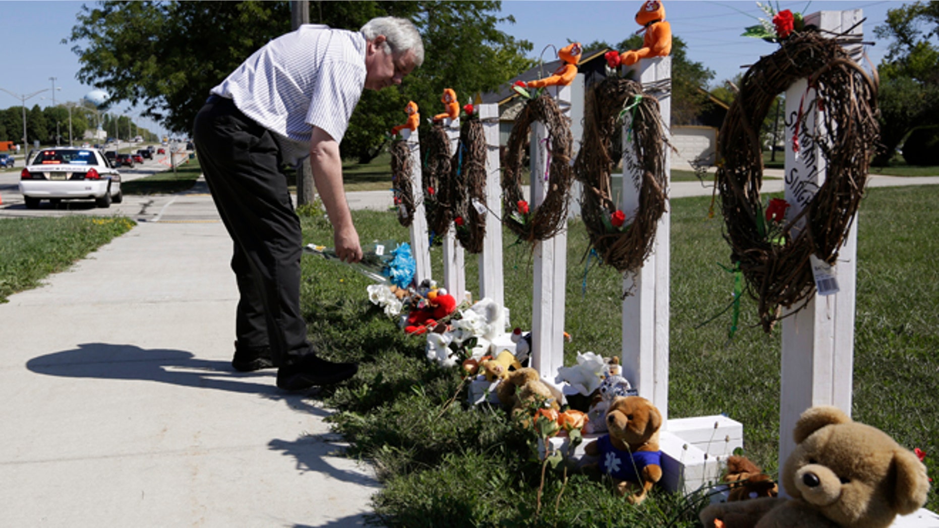 August 7, 2012: Peter Gallagher leaves flowers at a memorial honouring the six victims of a shooting at a Sikh Temple in Oak Creek, Wisconsin.