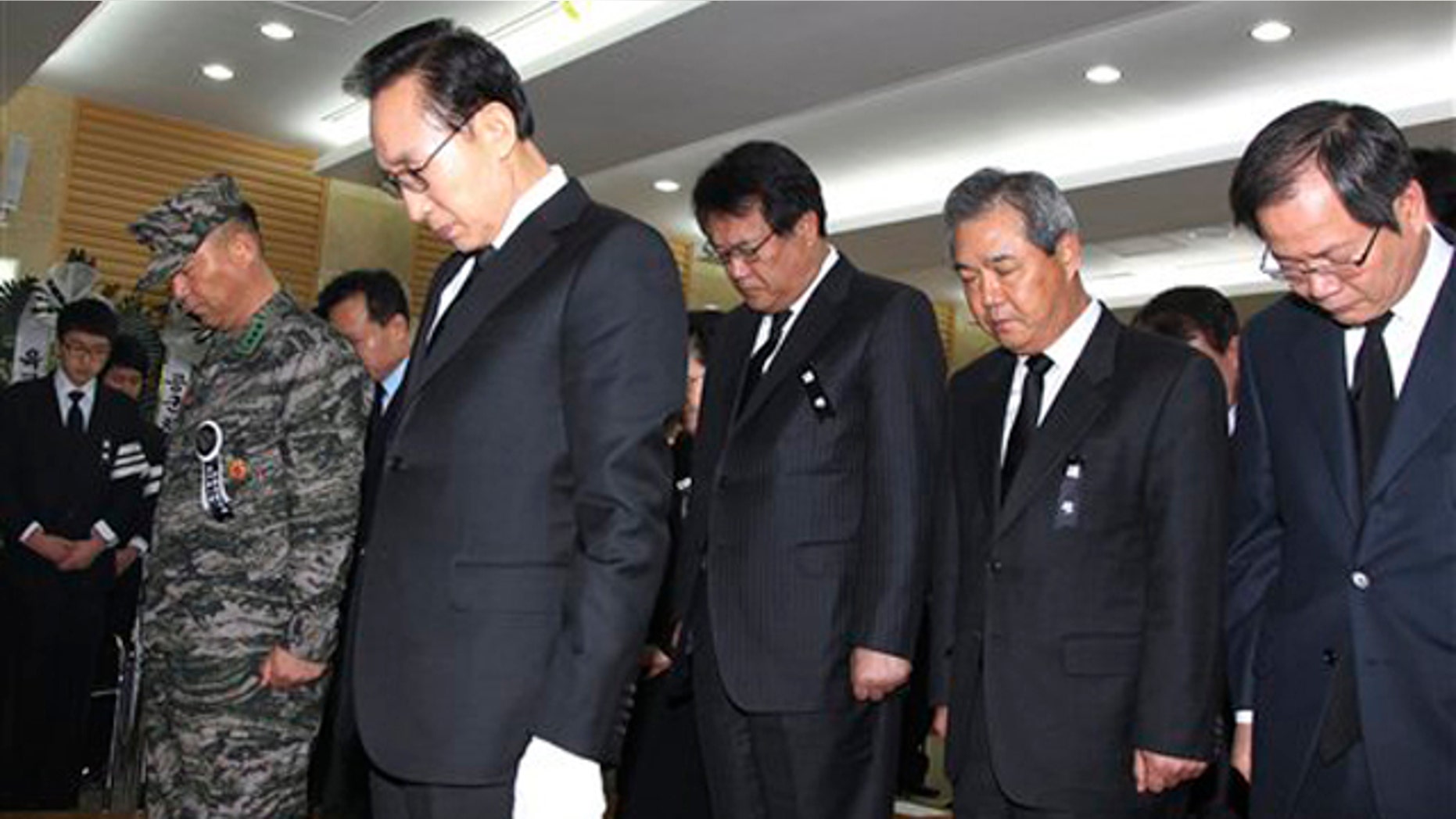 South Korean President Lee Myung-bak, second from left, and his cabinet members take moment of silence during a memorial service for South Korean Marines killed in a North Korean bombardment, at a military hospital in Seongnam, South Korea, Friday, Nov. 26, 2010.