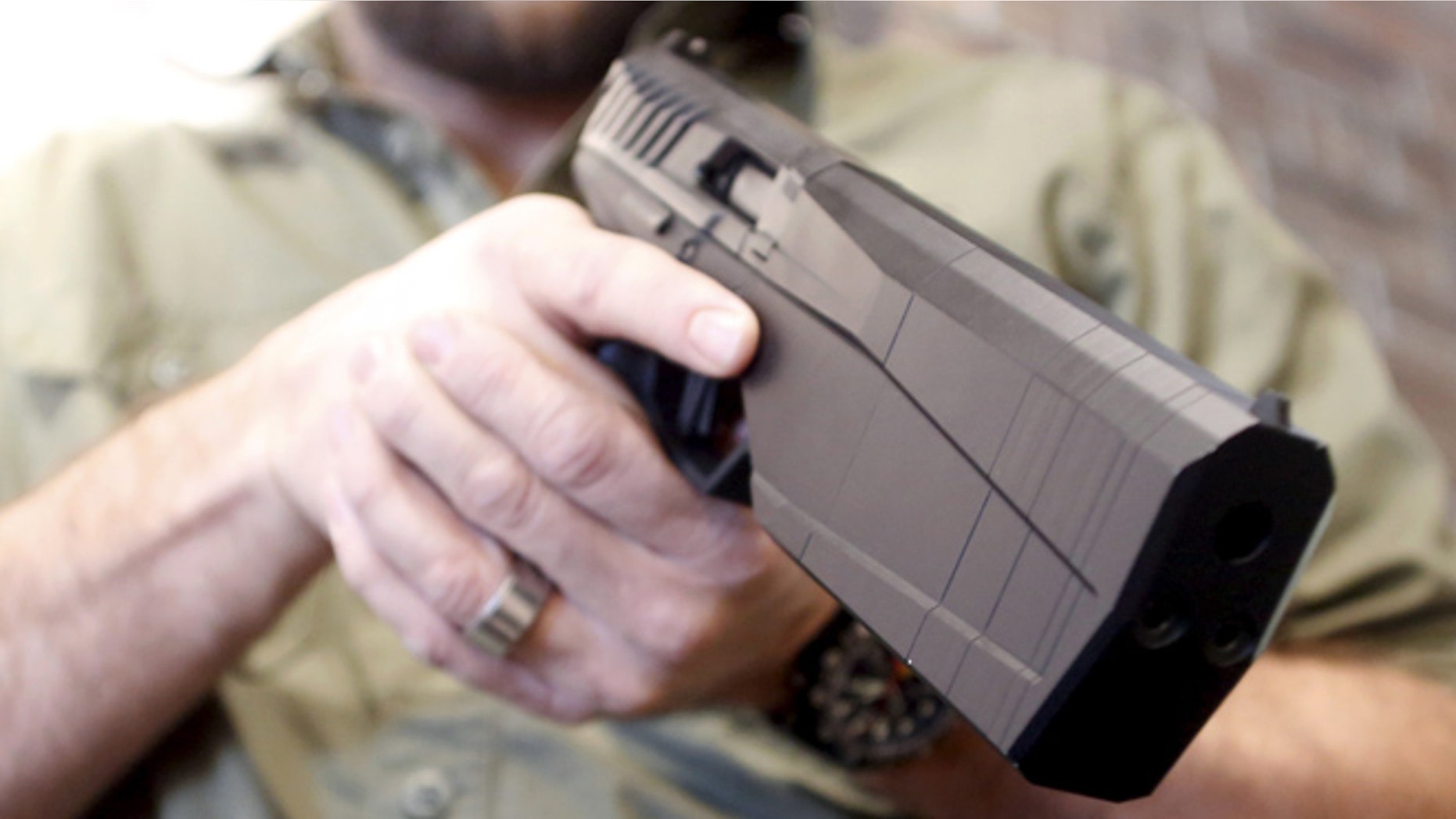 FILE: Feb. 23, 2016: SilencerCo CEO Joshua Waldron cradles a handgun with a built-in suppressor. West Valley City, Utah. (Reuters)