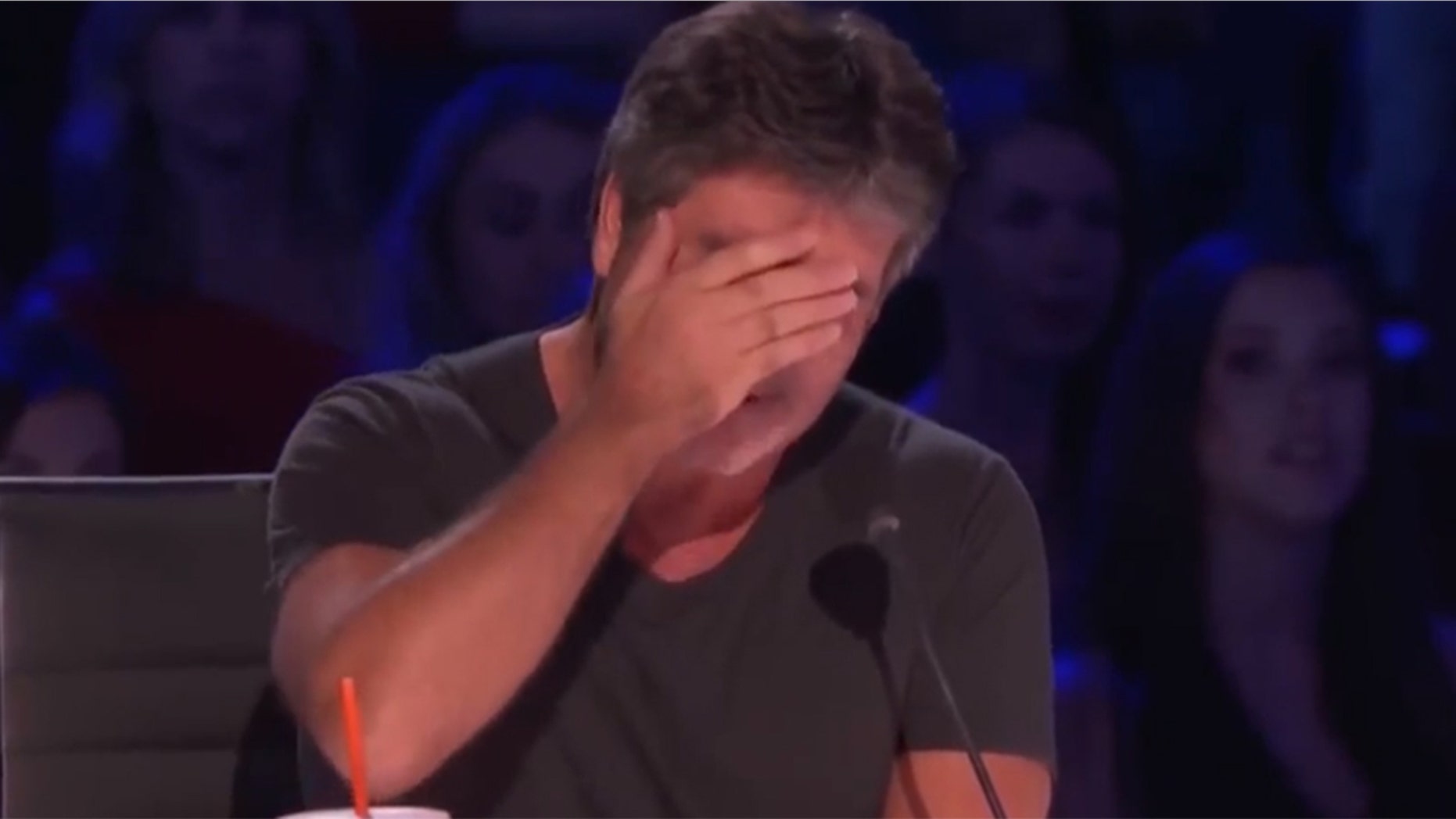 Simon Cowell attempts to hide his tears after an emotional performance from a contestant on "America's Got Talent."