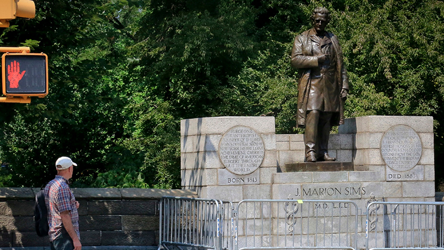 A man looks at the statue of Dr. J. Marion Sims in New York's Central Park.