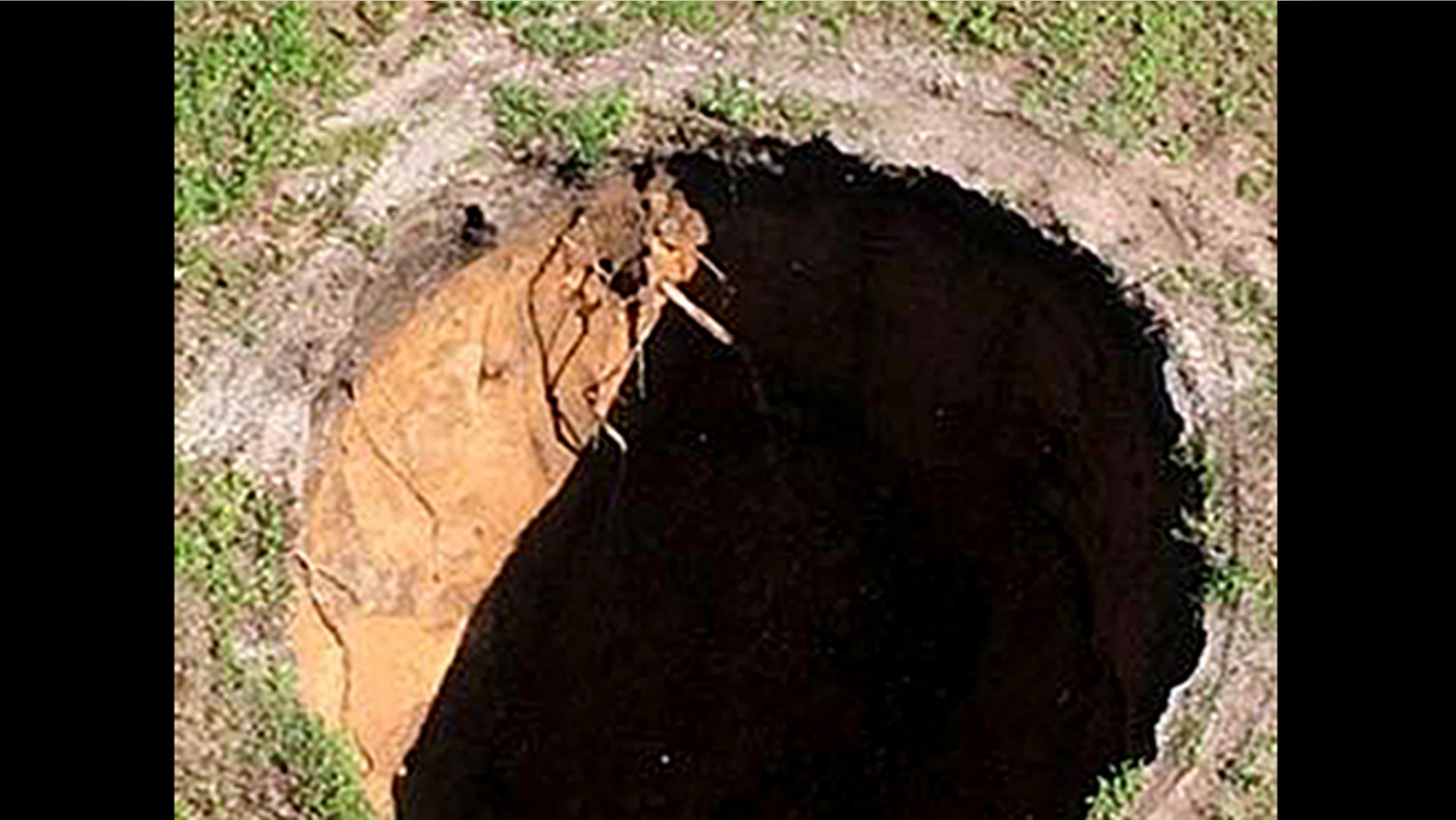 This image made from video provided by the Hillsborough County Fire Rescue, shows the property where a sinkhole reopened, Wednesday, Aug. 19, 2015, in Seffner, Fla.