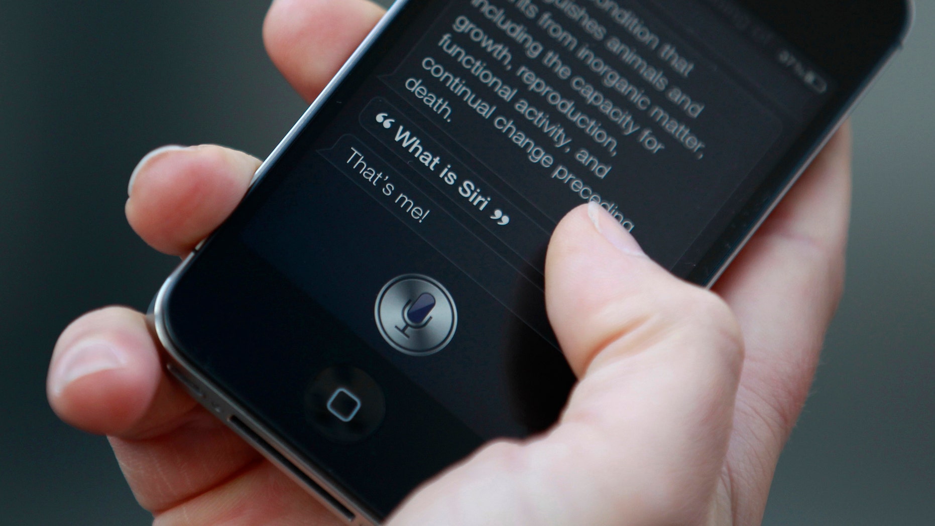 (File photo: Luke Peters demonstrates Siri, an application which uses voice recognition and detection on the iPhone 4S, outside the Apple store in Covent Garden, London October 14, 2011. (REUTERS/Suzanne Plunkett)