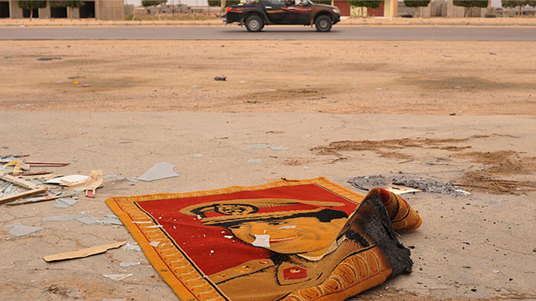 Oct. 3: A carpet depicting Muammar Qaddafi is seen on the road after Libyan revolutionary fighters took the village of Abu Hadi, near Sirte, Libya.