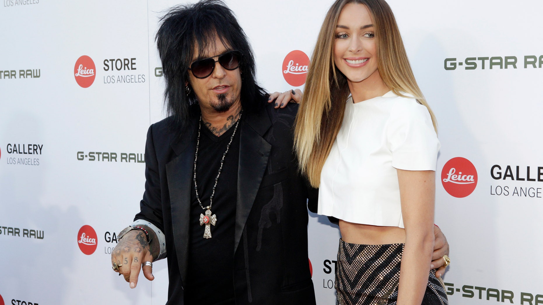 June 20, 2013. Musician Nikki Sixx and Courtney Bingham pose at the launch of the Leica Store Los Angeles in Los Angeles.