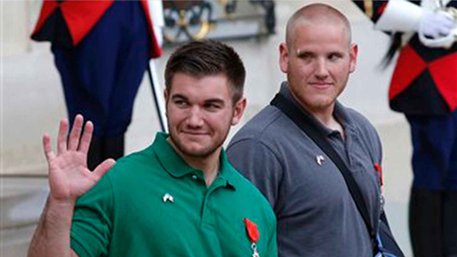 U.S. National Guardsman from Roseburg, Oregon, Alek Skarlatos , left, waves to the media as he leaves the Elysee Place in Paris, France, with U.S. Airman Spencer Stone, after being awarded with the French Legion of Honor by French President, Francois Hollande, Monday, Aug. 24, 2015. (AP Photo/Michel Euler)