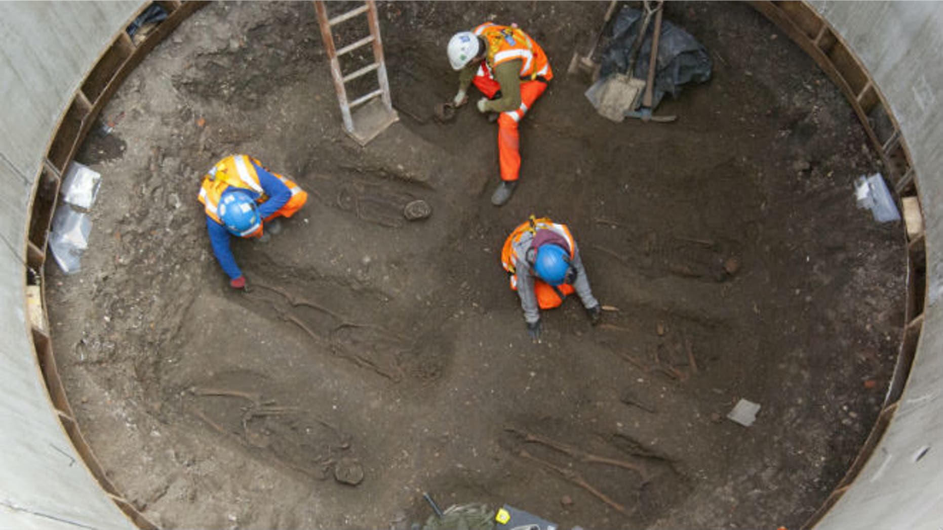 Archaeologists work on unearthed skeletons in the Farringdon area of London in this undated handout photograph released March 15, 2013. Archaeologists said on Friday they had found a graveyard during excavations for a rail project in London which might hold the remains of some 50,000 people killed by the "Black Death" plague more than 650 years ago. REUTERS/Crossrail/Handout