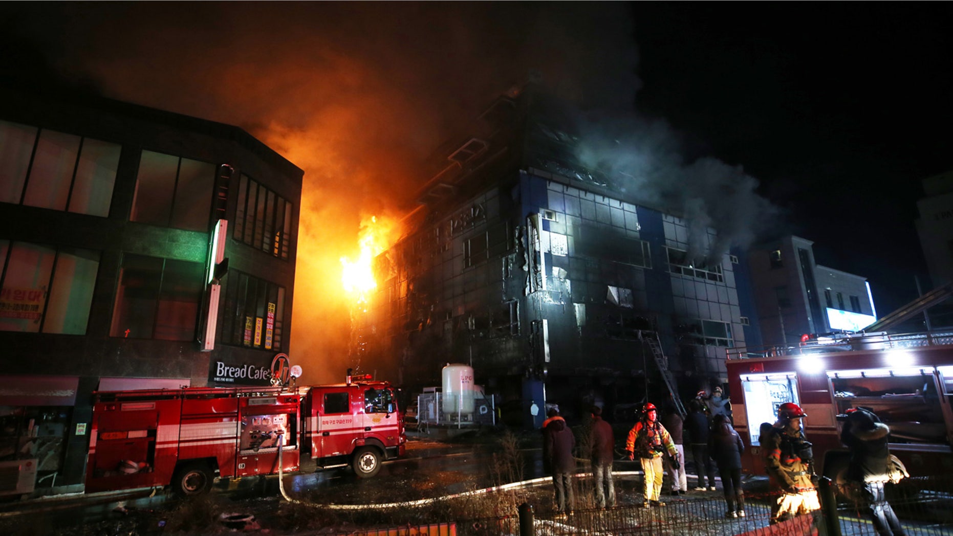 Firefighters try to extinguish a fire at an eight-floor building in Jecheon, South Korea, Thursday, Dec. 21, 2017. (Kim Hyung-woo/Yonhap via AP)