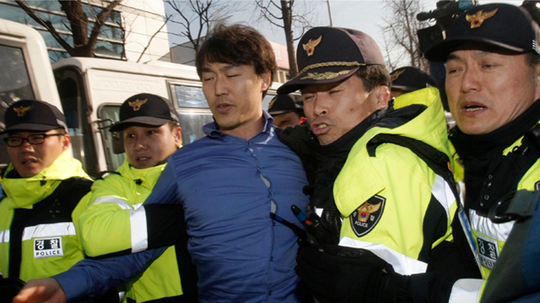 Dec. 13: A South Korean protester, center, is detained by police officers after ramming his car into a police bus guarding Chinese Embassy during a rally to denounce a Chinese fisherman, who killed a South Korea Coast Guard officer when a boat was stopped for suspected illegal fishing in South Korean waters, in Seoul.