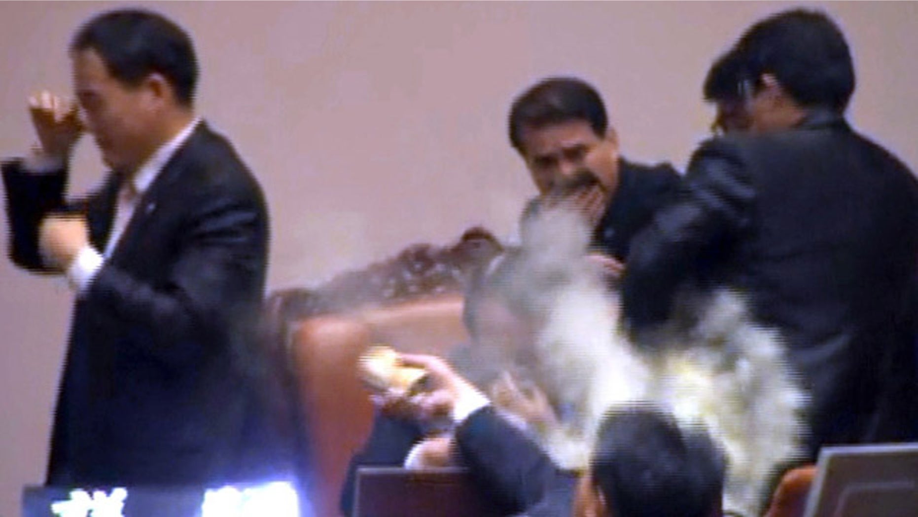 Nov. 22, 2011: Rep. Kim Seon-dong, bottom, of the opposition Democratic Labor Party, explodes tear gas in front of the speaker's chair to block National Assembly Vice Speaker Chung Eui-hwa, center, from pushing for the procedure to handle a pending bill on ratification of a South Korea-U.S. free trade agreement at the National Assembly in Seoul, South Korea.