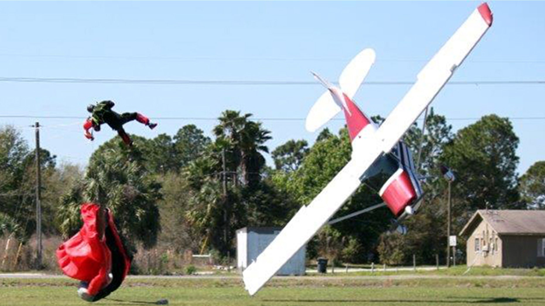 March 8, 2014: This photo released by the Polk County Sheriff's Office shows a plane nose-diving into the ground after getting tangled with a parachutist, left, at the South Lakeland Airport in Mulberry, Fla. Both the pilot and jumper hospitalized with minor injuries.